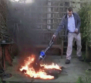 A gif of a man vacuuming up a small fire.